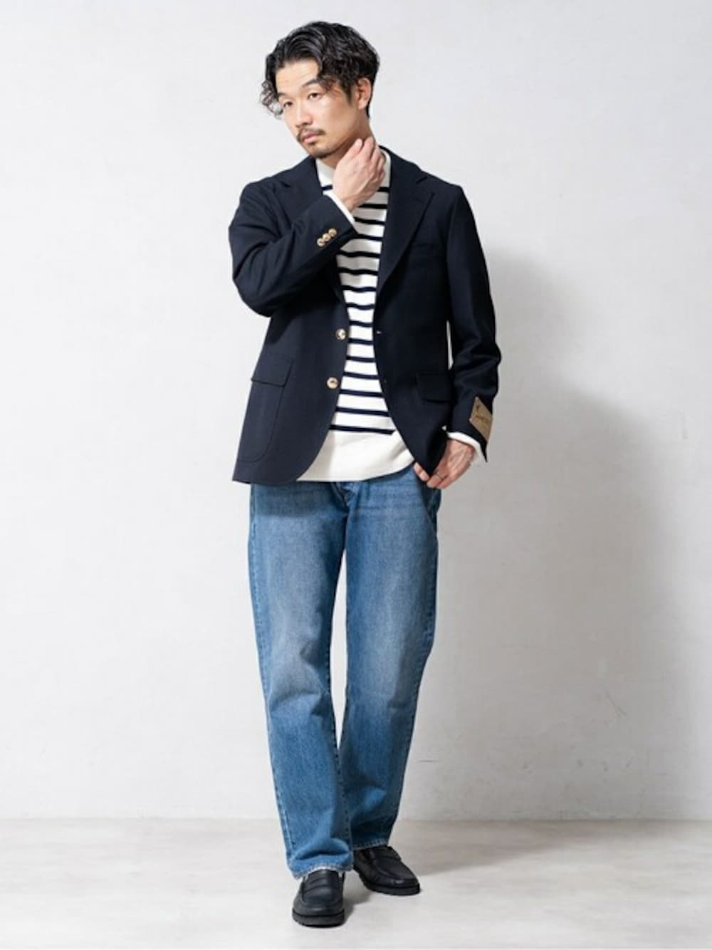 ブルー系のテーラードジャケット、ホワイト系のニット/セーター、ブルー系のデニムパンツを着用したメンズの冬コーディネートの1枚目の写真