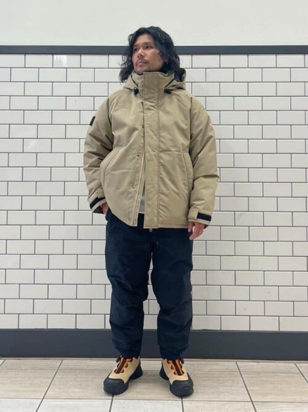 ベージュ系のダウンジャケット/コート、ブラック系のその他パンツ、ベージュ系のスニーカーを着用したメンズの冬コーディネートの1枚目の写真