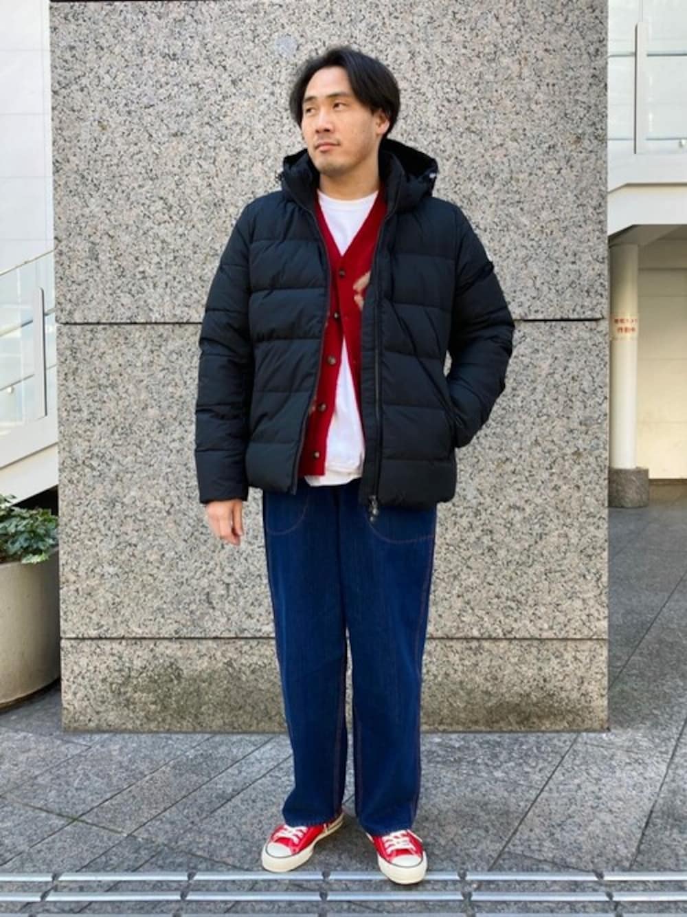 ブラック系のダウンジャケット/コート、レッド系のカーディガン/ボレロ、ブルー系のデニムパンツを着用したメンズの冬コーディネートの1枚目の写真