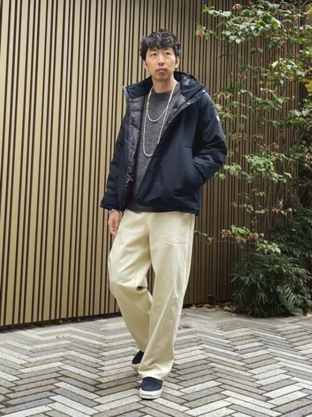 ブラック系のダウンジャケット/コート、グレー系のニット/セーター、ホワイト系のデニムパンツを着用したメンズの冬コーディネートの1枚目の写真