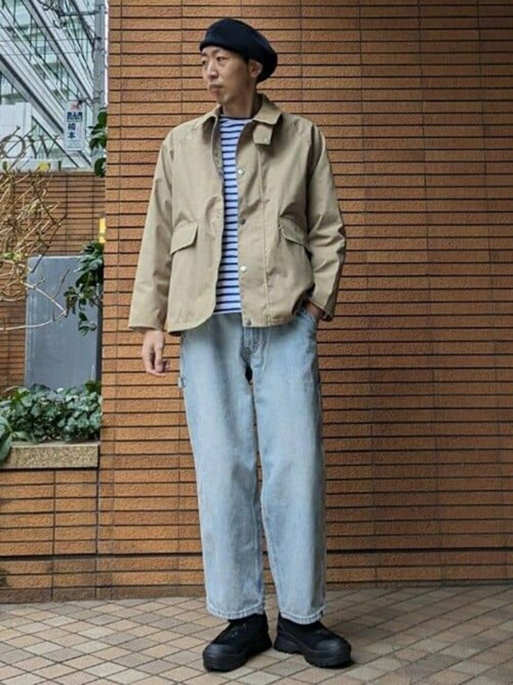ベージュ系のカバーオール、ブルー系のデニムパンツ、ベージュ系のスニーカーを着用したメンズの冬コーディネートの1枚目の写真