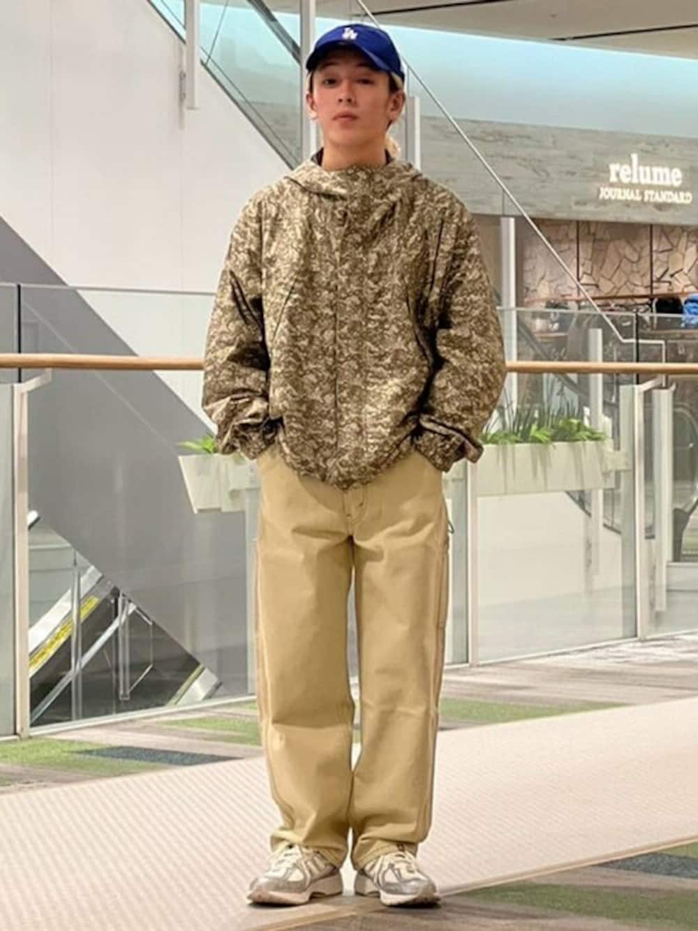 ベージュ系のマウンテンパーカー、ベージュ系のデニムパンツ、シルバー系のスニーカーを着用したメンズの冬コーディネートの1枚目の写真