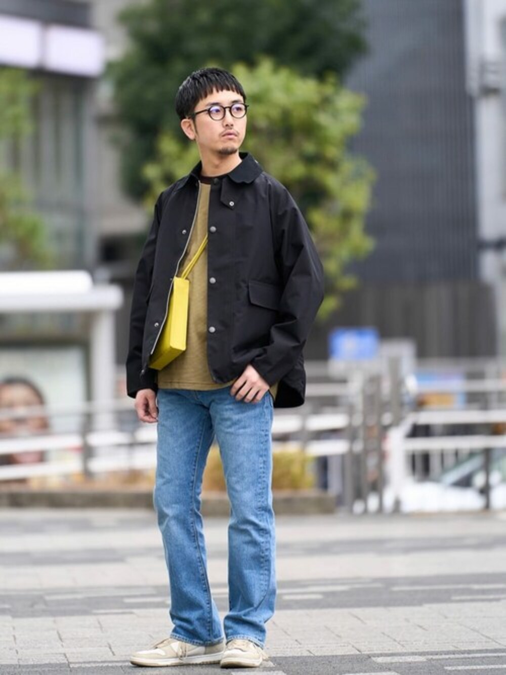 ブラック系のカバーオール、ブラウン系のTシャツ/カットソー、ブルー系のデニムパンツを着用したメンズの春コーディネートの1枚目の写真