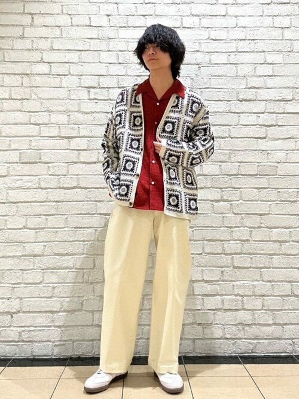 ホワイト系のカーディガン/ボレロ、ホワイト系のスラックス、ホワイト系のスニーカーを着用したメンズの春コーディネートの1枚目の写真