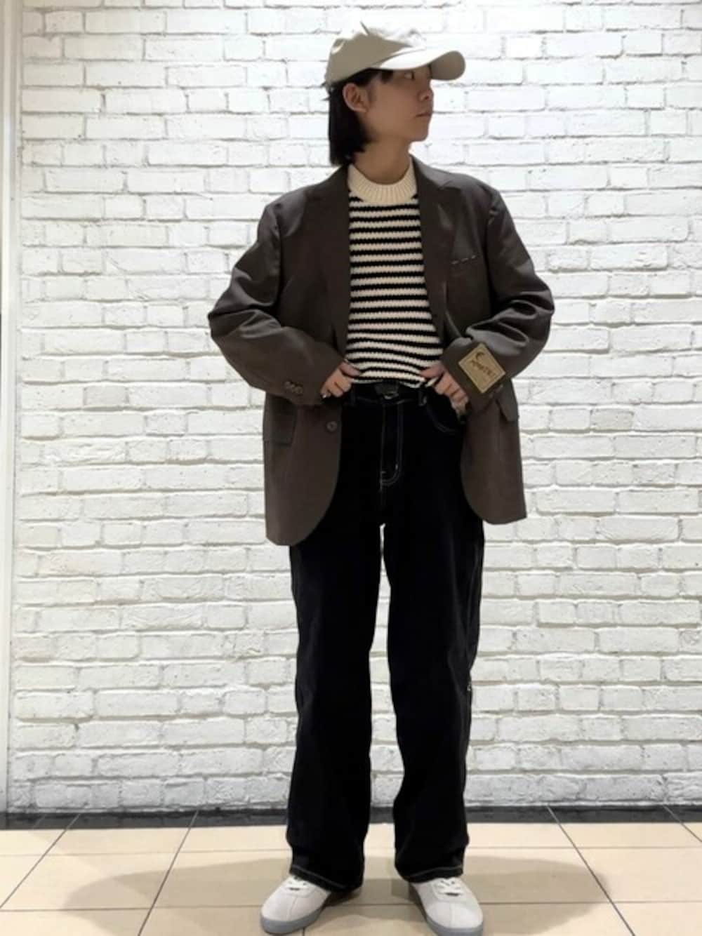 ブラウン系のテーラードジャケット、ブラック系のデニムパンツ、グレー系のスニーカーを着用したメンズの春コーディネートの1枚目の写真