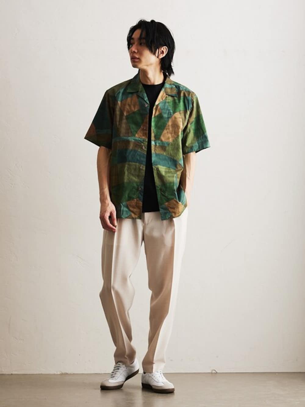 グリーン系のシャツ/ブラウス、ブラック系のTシャツ/カットソー、ベージュ系のスラックスを着用したメンズの春コーディネートの1枚目の写真