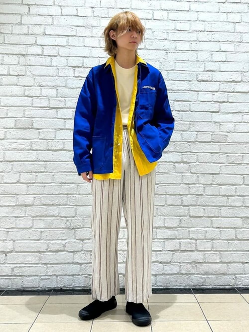 ブルー系のカバーオール、イエロー系のシャツ/ブラウス、ホワイト系のTシャツ/カットソーを着用したメンズの春コーディネートの1枚目の写真