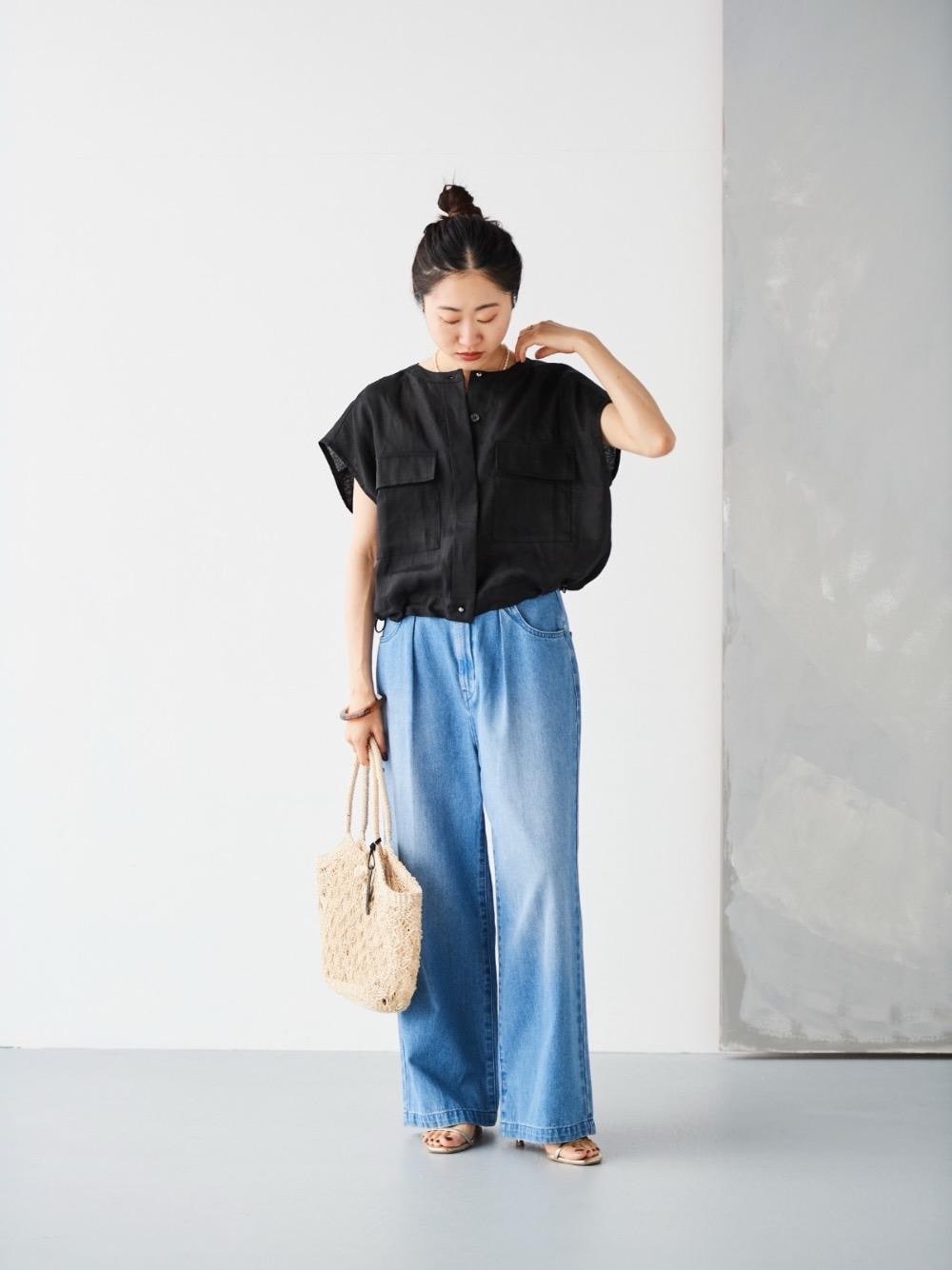 ブルー系のデニムパンツ、ベージュ系のかごバッグ、ブラック系のその他アウターを着用したレディースの夏コーディネートの1枚目の写真