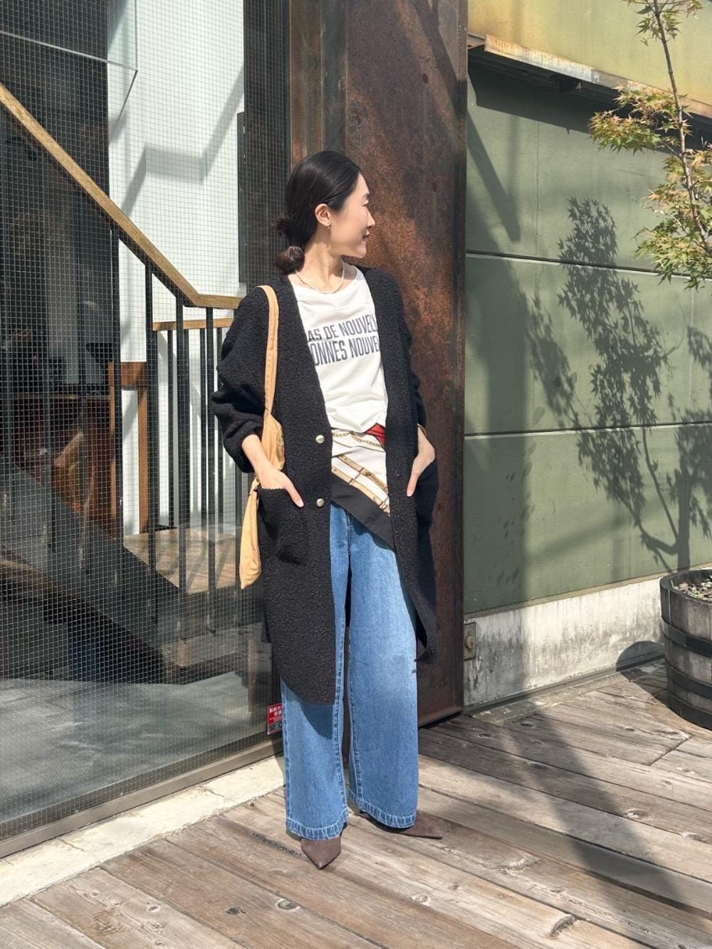 ホワイト系のTシャツ/カットソー、ブルー系のデニムパンツ、ブラック系のノーカラーコートを着用したレディースの秋コーディネートの1枚目の写真