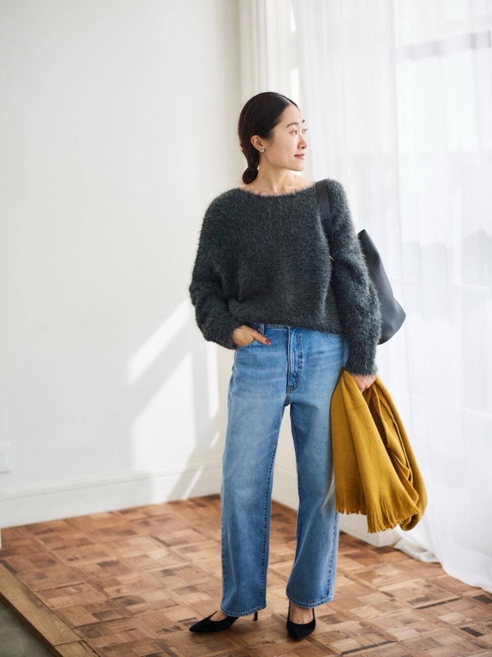 ブルー系のデニムパンツ、グレー系のニット/セーター、ブラック系のショルダーバッグを着用したレディースの秋コーディネートの1枚目の写真