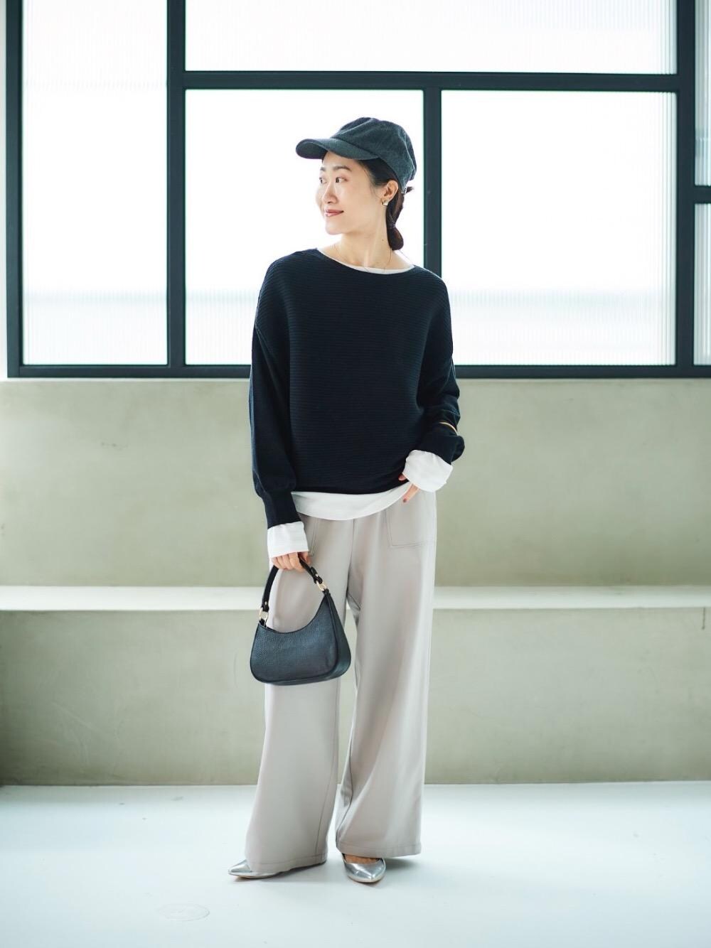ホワイト系のTシャツ/カットソー、ブラック系のニット/セーター、ブラック系のショルダーバッグを着用したレディースの秋コーディネートの1枚目の写真