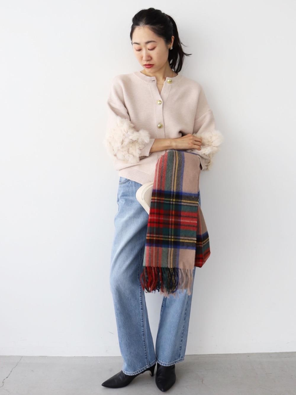 ブルー系のデニムパンツ、ホワイト系のニット/セーター、ベージュ系のストール/ショールを着用したレディースの秋コーディネートの1枚目の写真