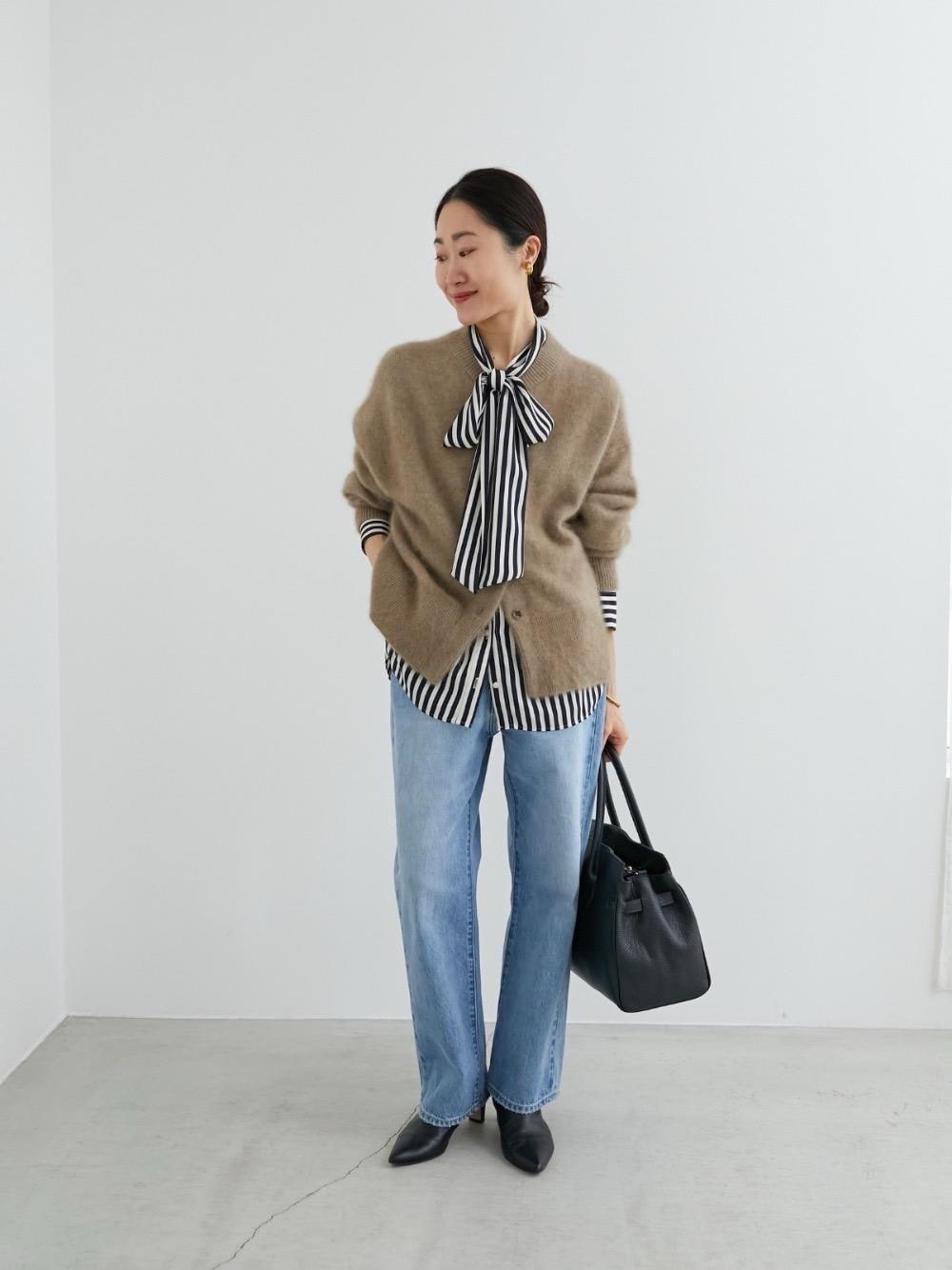 ブルー系のデニムパンツ、ホワイト系のシャツ/ブラウス、ブラウン系のカーディガン/ボレロを着用したレディースの冬コーディネートの1枚目の写真