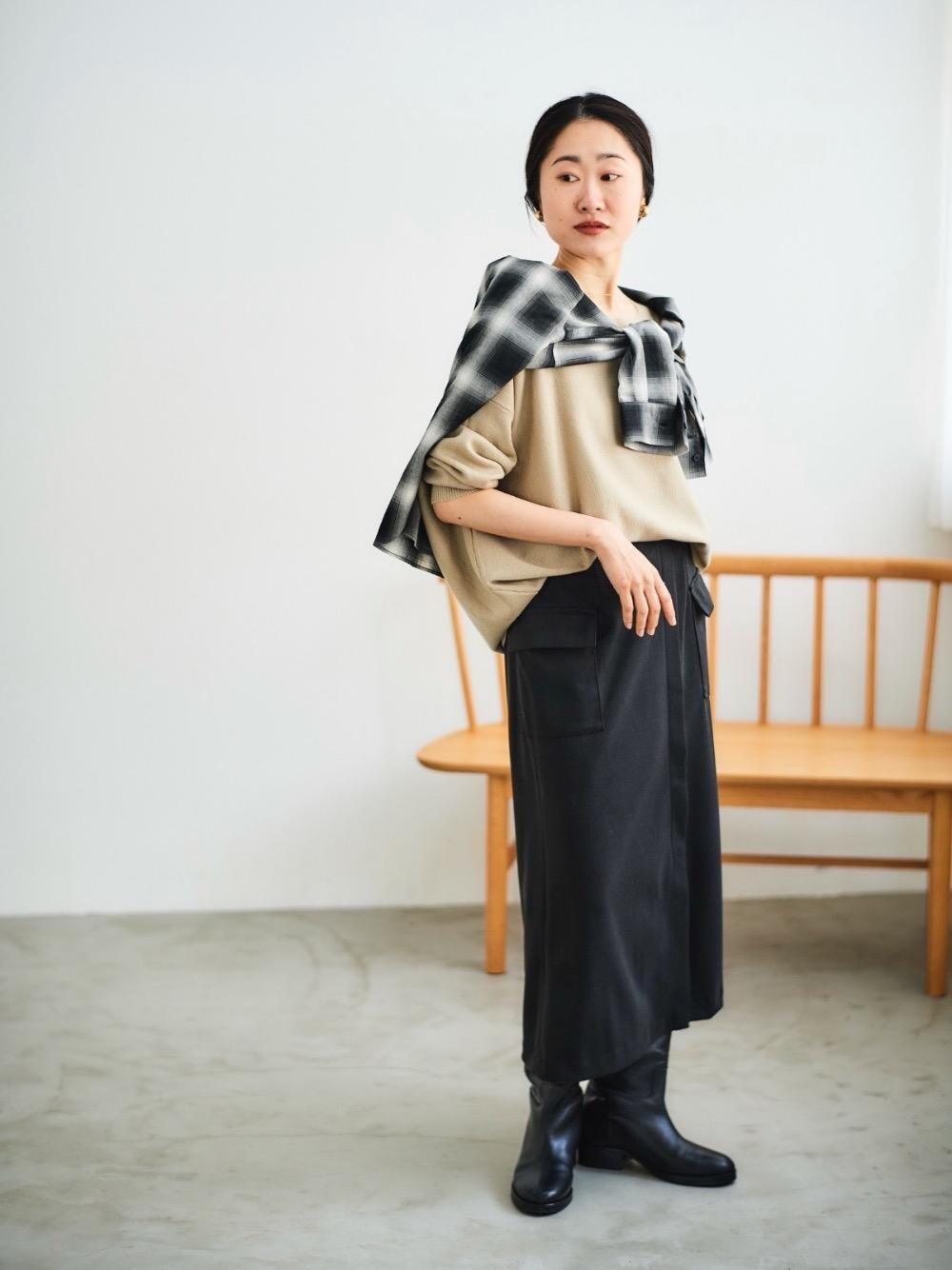 ベージュ系のニット/セーター、ブラック系のスカートを着用したレディースの冬コーディネートの1枚目の写真