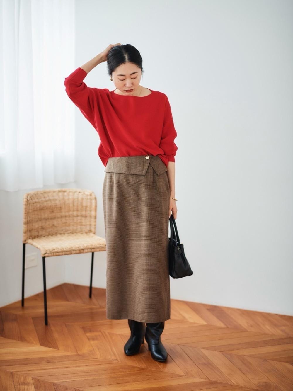 レッド系のニット/セーター、ブラウン系のスカートを着用したレディースの冬コーディネートの1枚目の写真