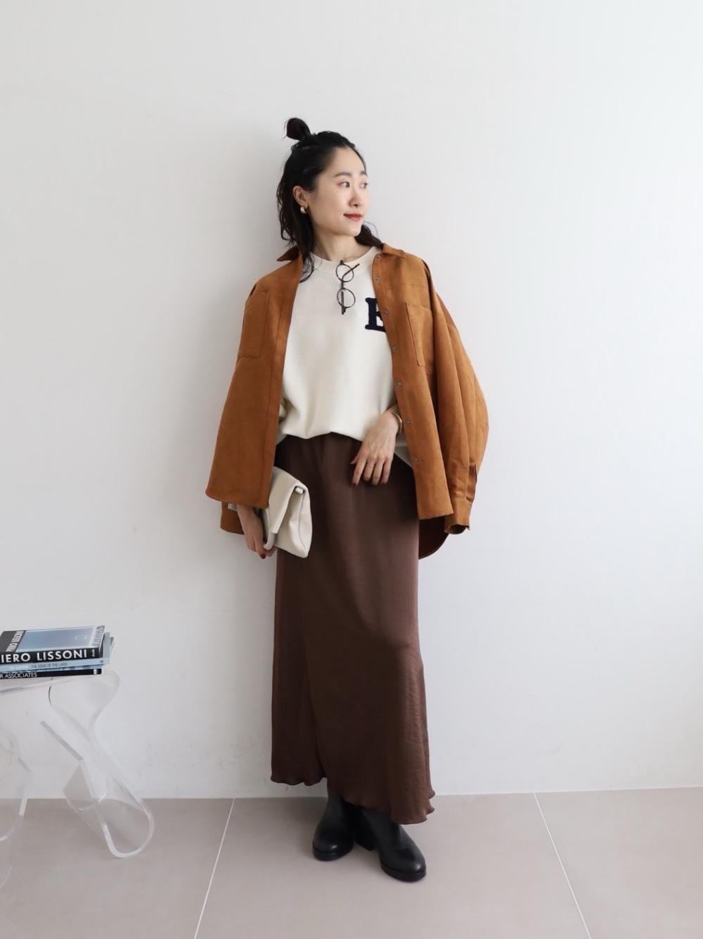 ホワイト系のハンドバッグ、イエロー系のシャツ/ブラウス、ホワイト系のニット/セーターを着用したレディースの秋コーディネートの1枚目の写真