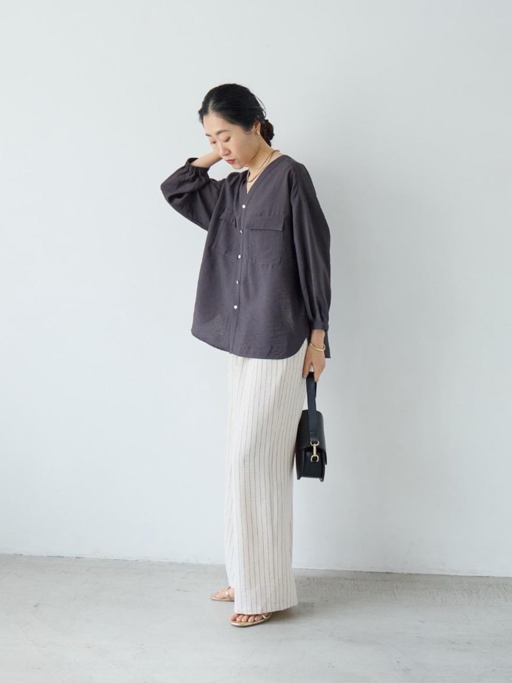 ホワイト系のその他パンツ、グレー系のシャツ/ブラウス、ゴールド系のネックレスを着用したレディースの春コーディネートの1枚目の写真