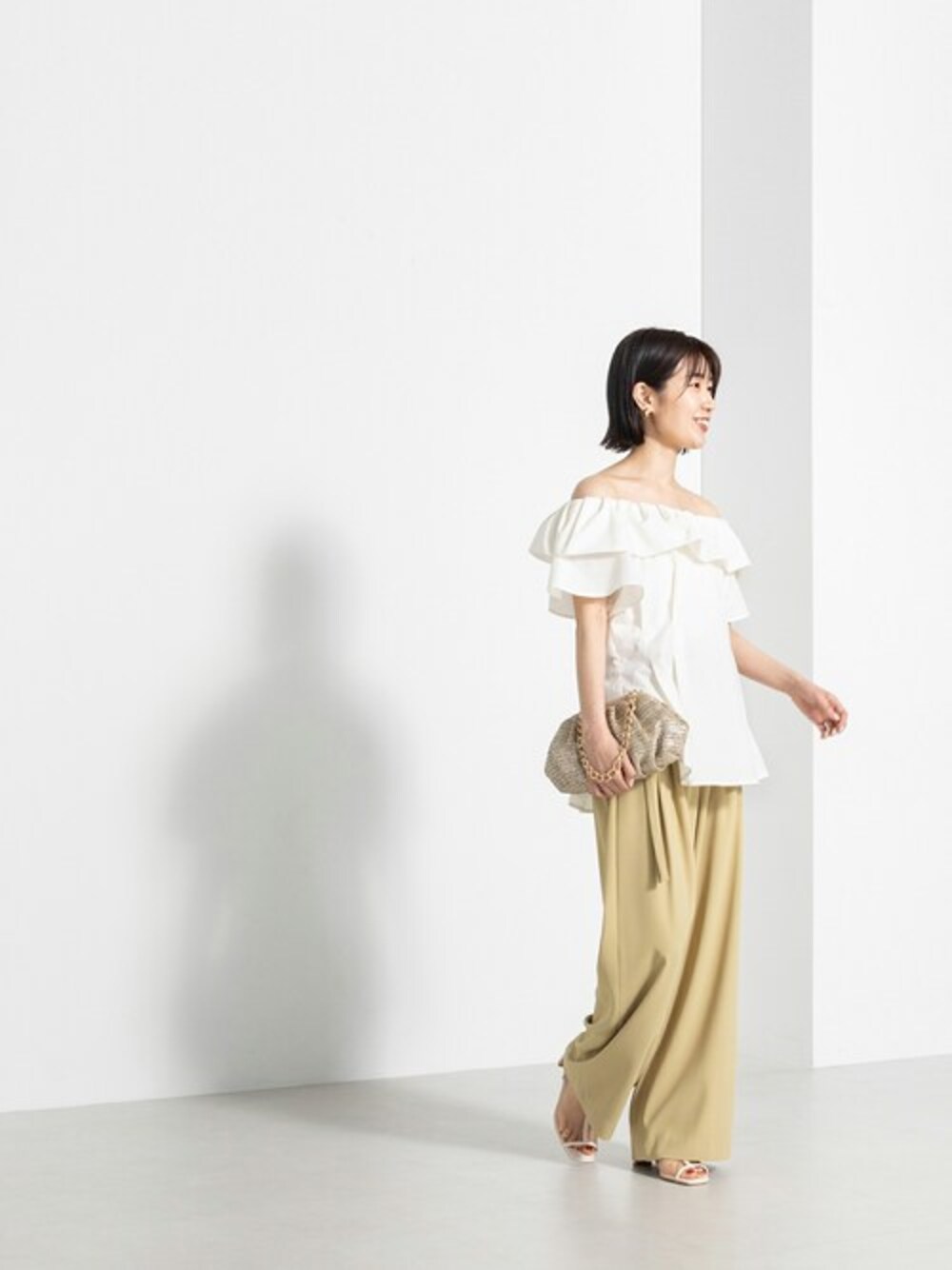 ホワイト系のシャツ/ブラウス、イエロー系のその他パンツ、ベージュ系のショルダーバッグを着用したレディースの春コーディネートの1枚目の写真