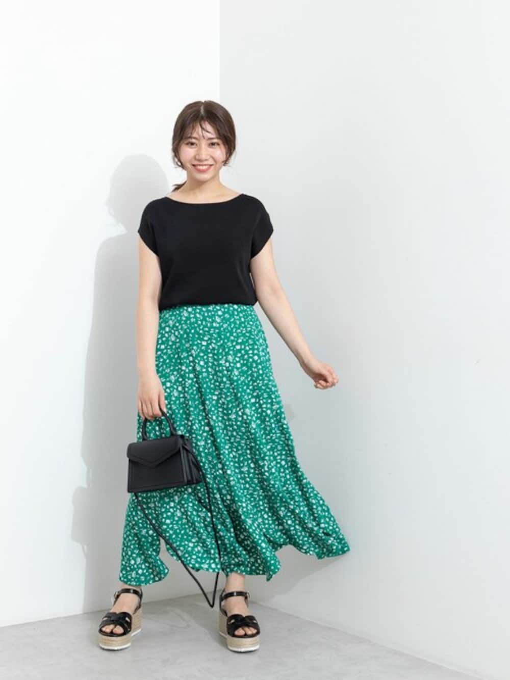 ブラック系のニット/セーター、グリーン系のスカート、ブラック系のトートバッグを着用したレディースの春コーディネートの1枚目の写真