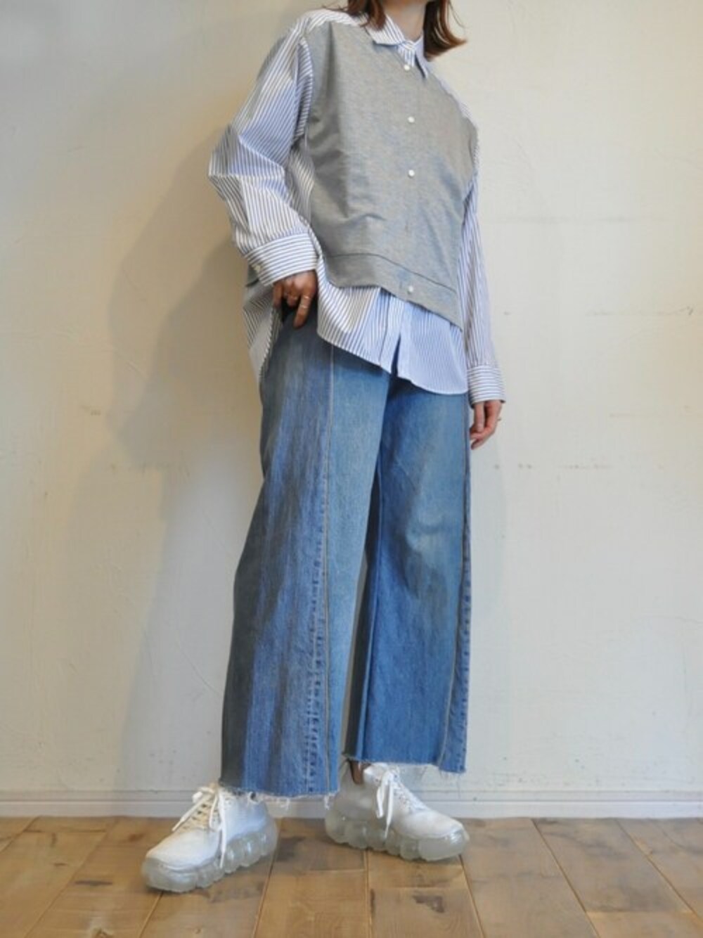 ブルー系のデニムパンツ、グレー系のシャツ/ブラウスを着用したレディースの春コーディネートの1枚目の写真
