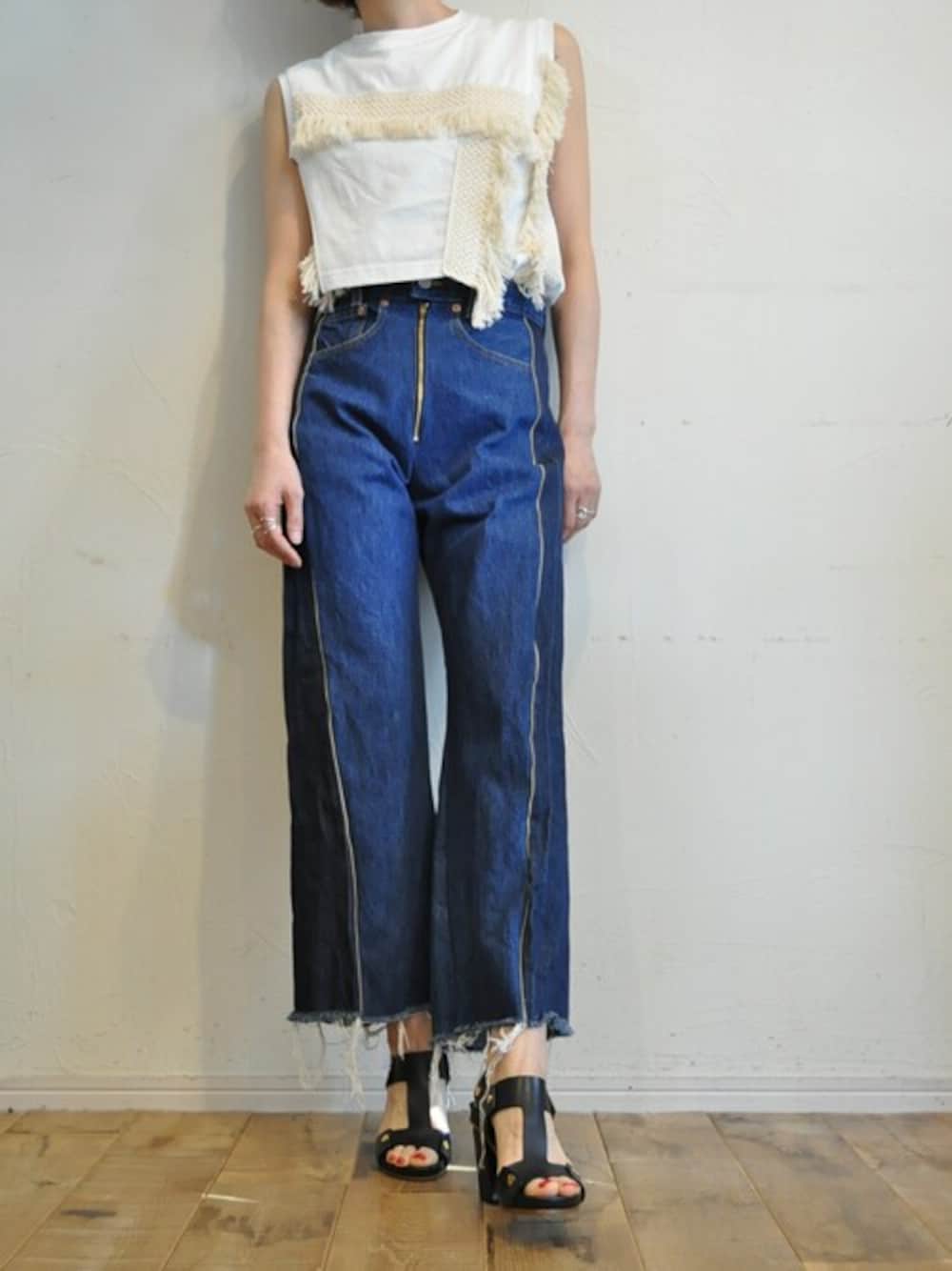 ホワイト系のタンクトップ、ブルー系のデニムパンツを着用したレディースの夏コーディネートの1枚目の写真