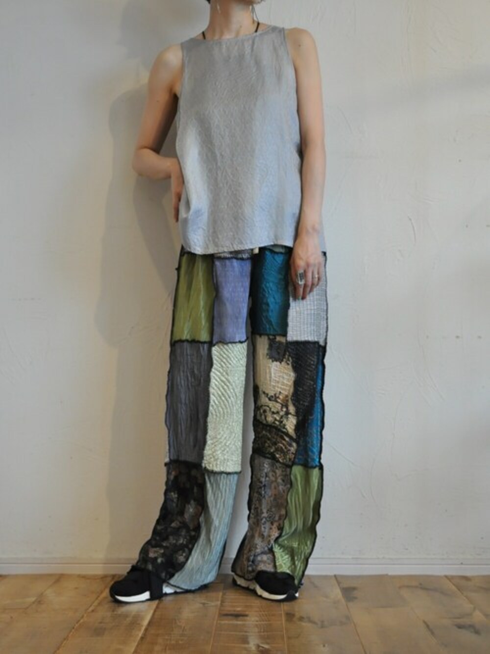 シルバー系のタンクトップ、ブラック系のその他パンツを着用したレディースの夏コーディネートの1枚目の写真