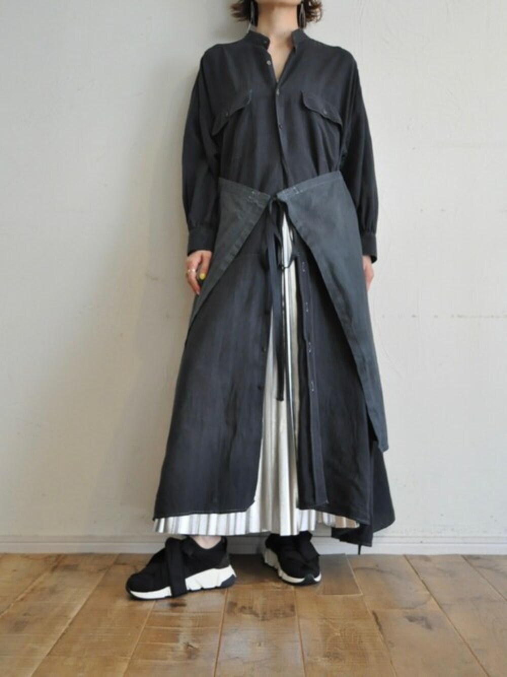 ブラック系のシャツワンピース、シルバー系のスカートを着用したレディースの冬コーディネートの1枚目の写真