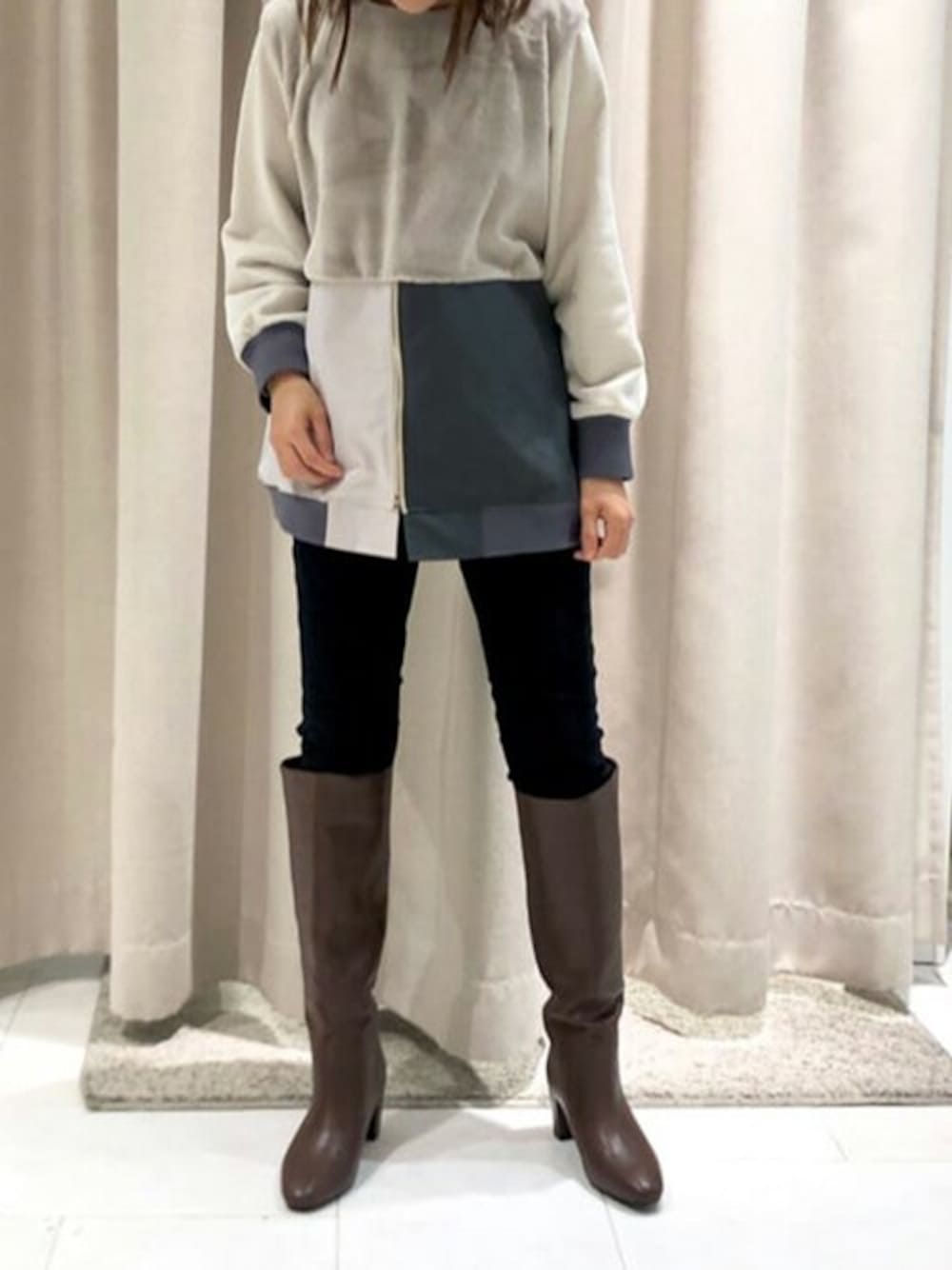 ホワイト系のニット/セーター、ブラック系のその他パンツ、ブラウン系のブーツを着用したレディースの冬コーディネートの1枚目の写真