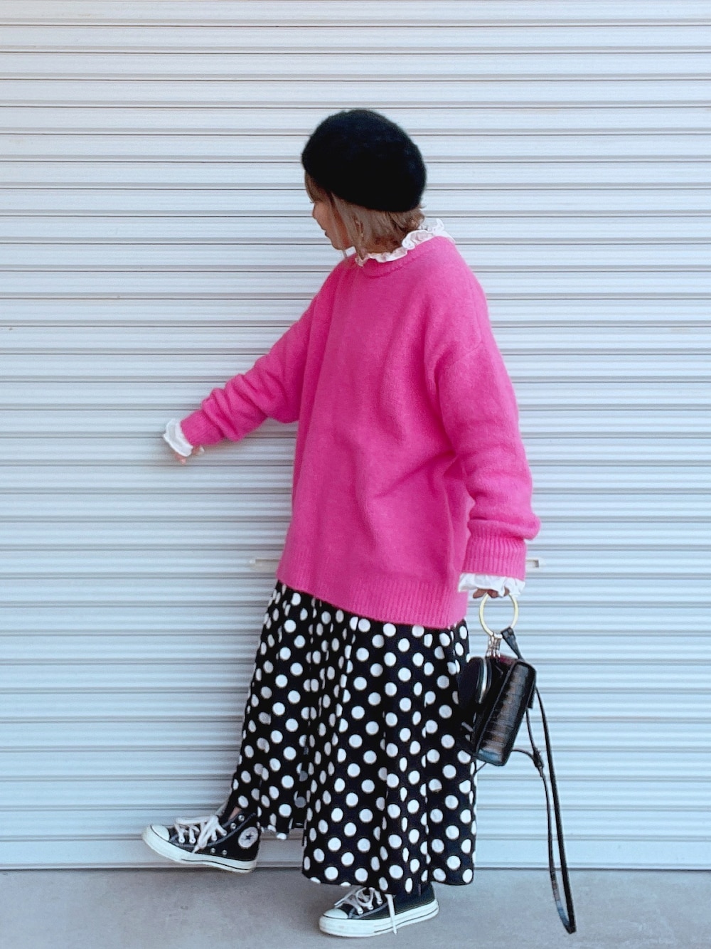 ピンク系のニット/セーター、ホワイト系のシャツ/ブラウス、ブラック系のスカートを着用したレディースの冬コーディネートの1枚目の写真