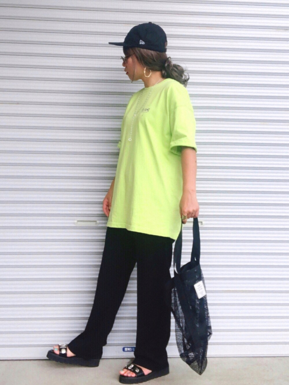 イエロー系のTシャツ/カットソー、ブラック系のスラックス、ブラック系のサンダルを着用したレディースの夏コーディネートの1枚目の写真