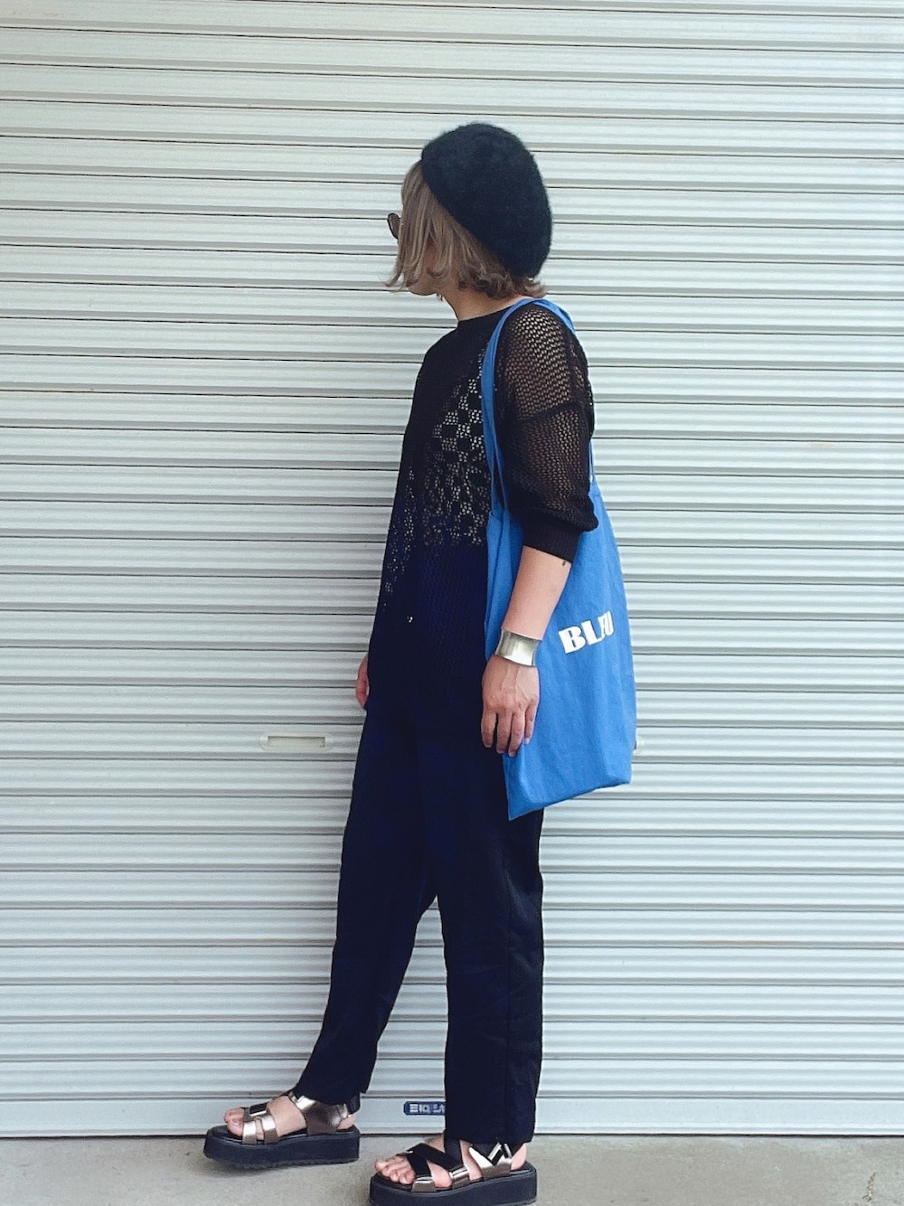 ブラック系のニット/セーター、ブラック系のタンクトップ、ブラック系のスラックスを着用したレディースの春コーディネートの1枚目の写真