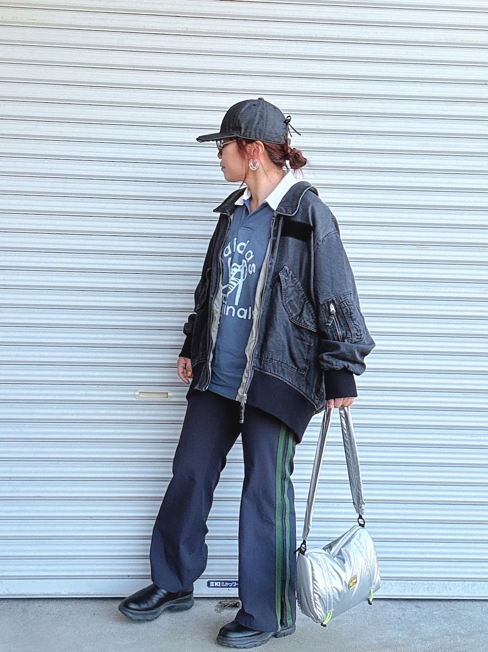 ブルー系のポロシャツ、ブラック系のブルゾン、シルバー系のショルダーバッグを着用したレディースの冬コーディネートの1枚目の写真