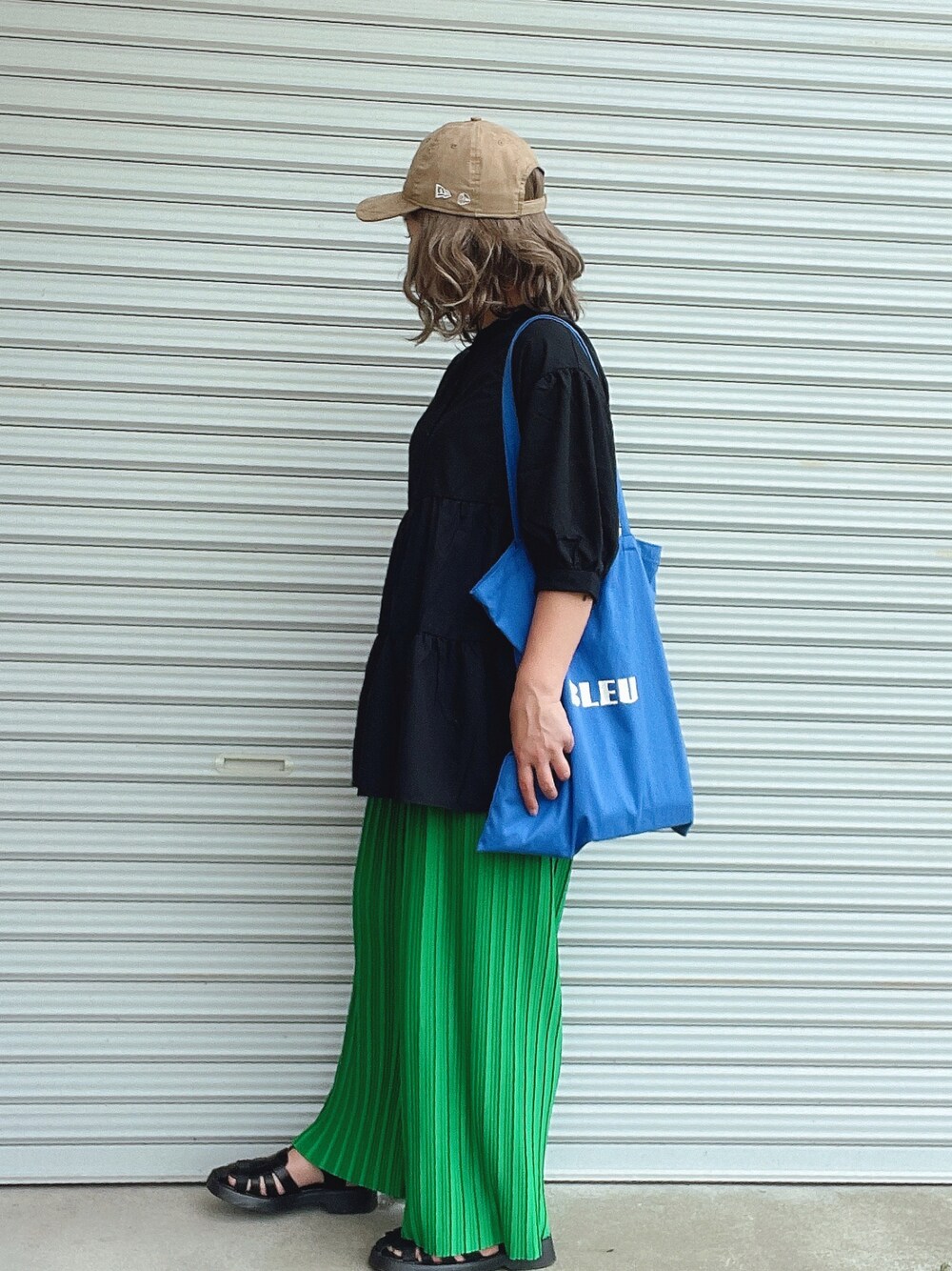 ブラック系のシャツ/ブラウス、グリーン系のその他パンツ、ブルー系のトートバッグを着用したレディースの春コーディネートの1枚目の写真