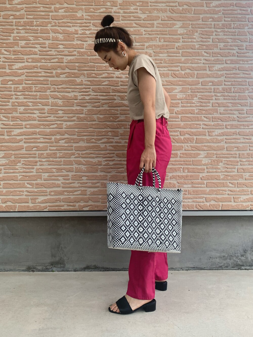 ブラック系のハンドバッグ、ピンク系のスラックス、その他のカチューシャを着用したレディースの夏コーディネートの1枚目の写真