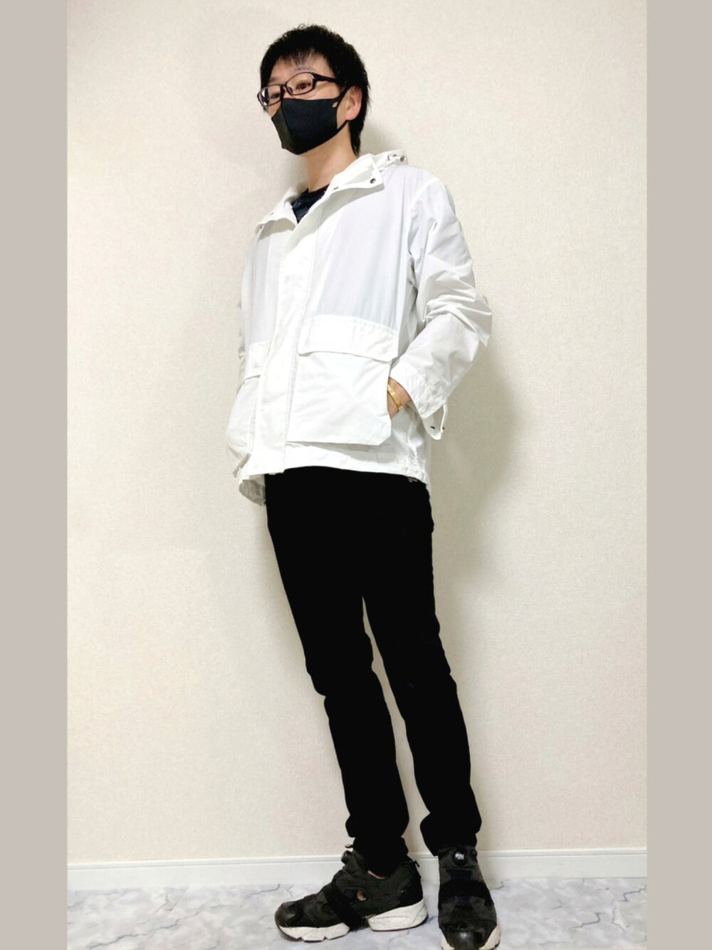 ブラック系のその他パンツ、ブラック系のスニーカー、ホワイト系のマウンテンパーカーを着用したメンズの秋コーディネートの1枚目の写真