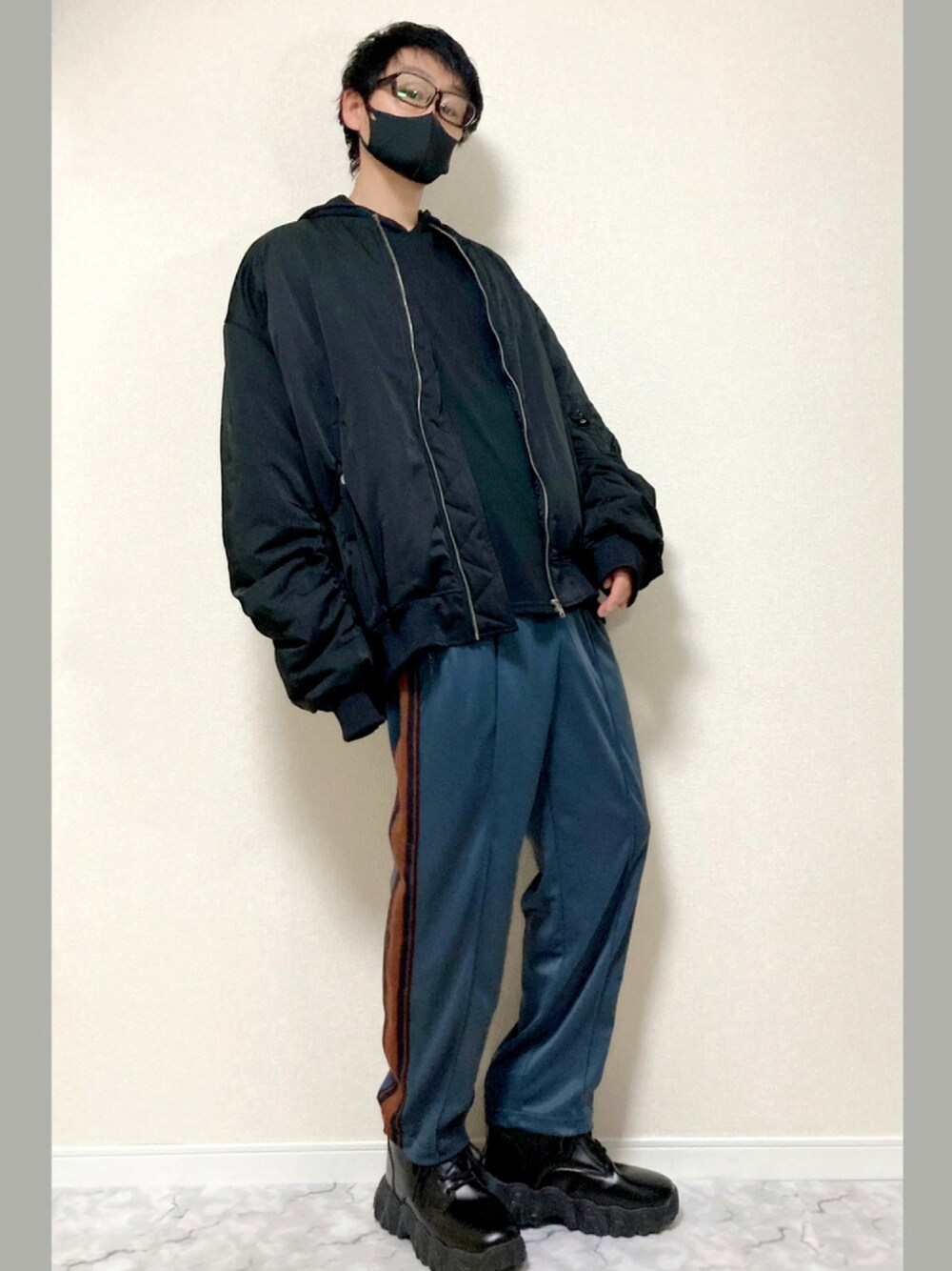 ブルー系のパンツ、ブラック系のブーツ、ブラック系のMA-1を着用したメンズの秋コーディネートの1枚目の写真