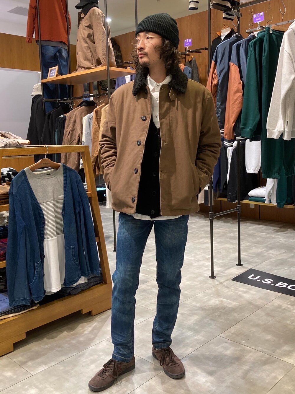 ブラック系のカーディガン/ボレロ、ブラウン系のミリタリージャケット、ホワイト系のシャツ/ブラウスを着用したメンズの冬コーディネートの1枚目の写真