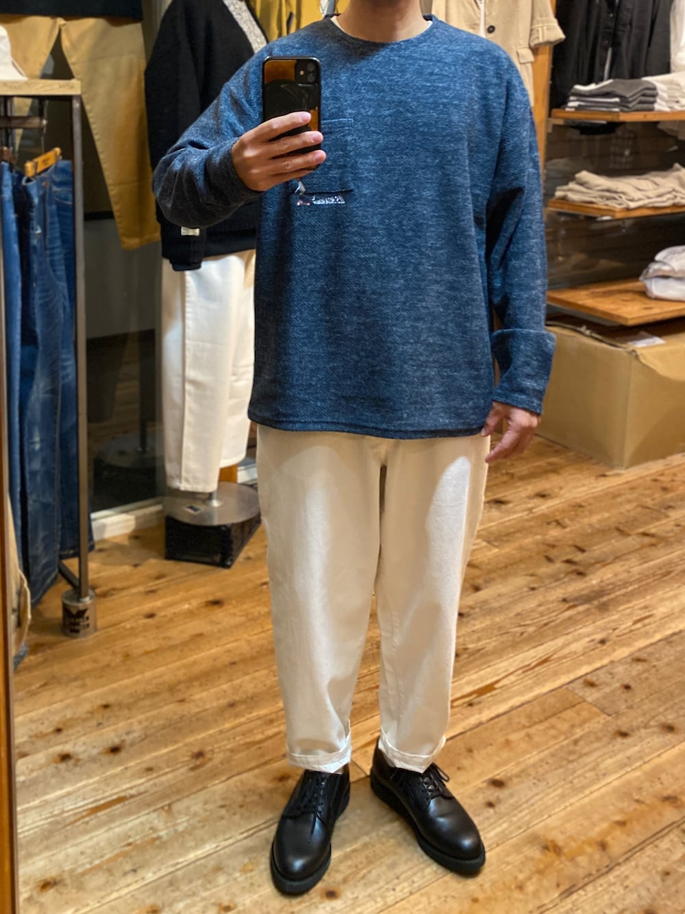 ブルー系のニット/セーター、ホワイト系のデニムパンツ、ブラック系のブーツを着用したメンズの冬コーディネートの1枚目の写真