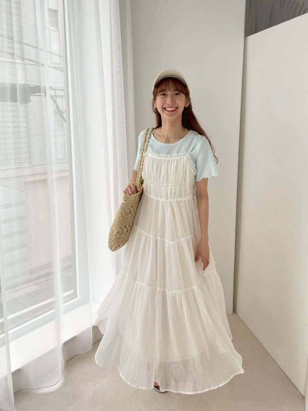 ホワイト系のワンピース、ブルー系のTシャツ/カットソー、ベージュ系のトートバッグを着用したレディースの春コーディネートの1枚目の写真