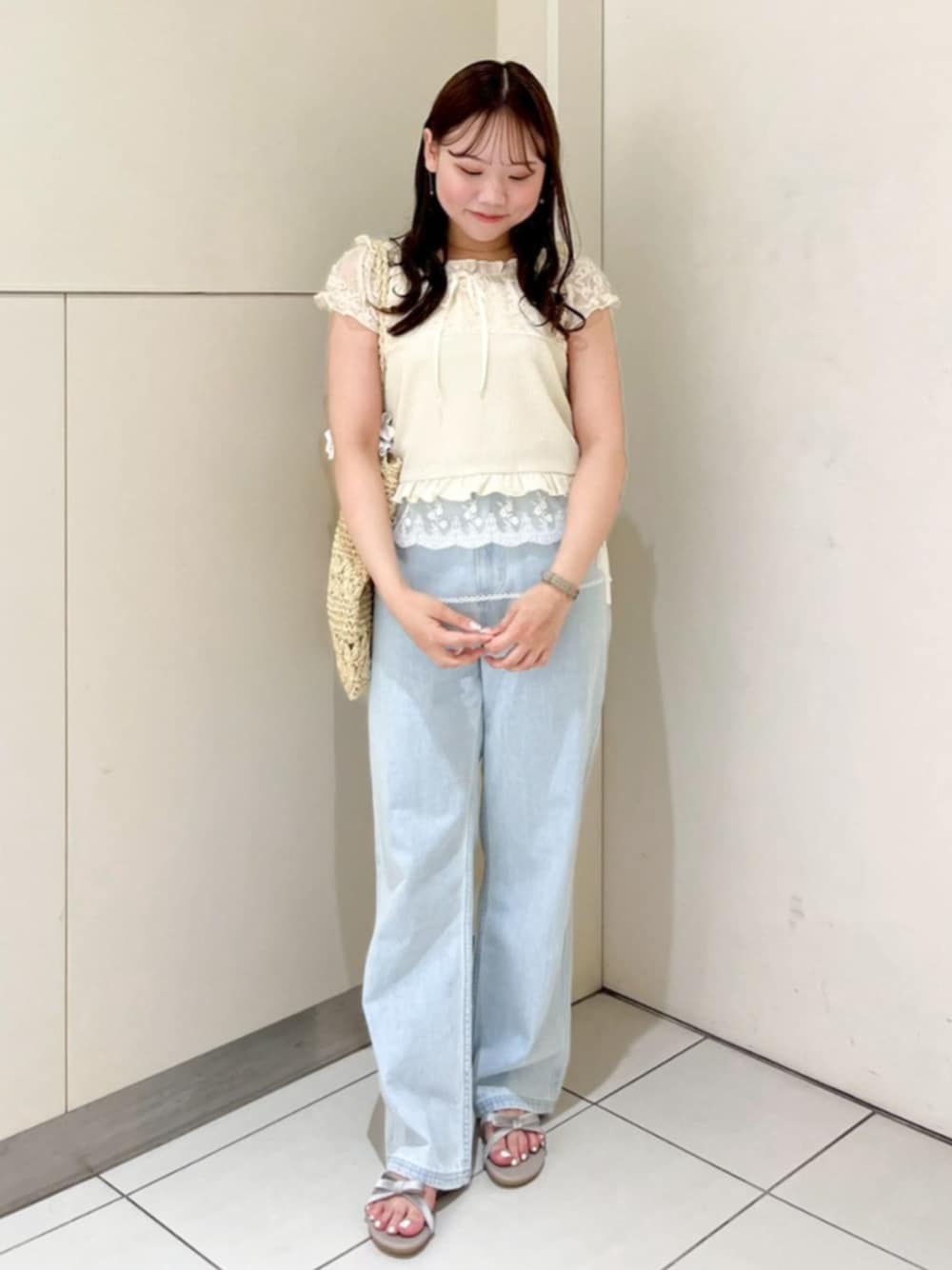ホワイト系のかごバッグ、ブルー系のデニムパンツ、ホワイト系のスカートを着用したレディースの夏コーディネートの1枚目の写真
