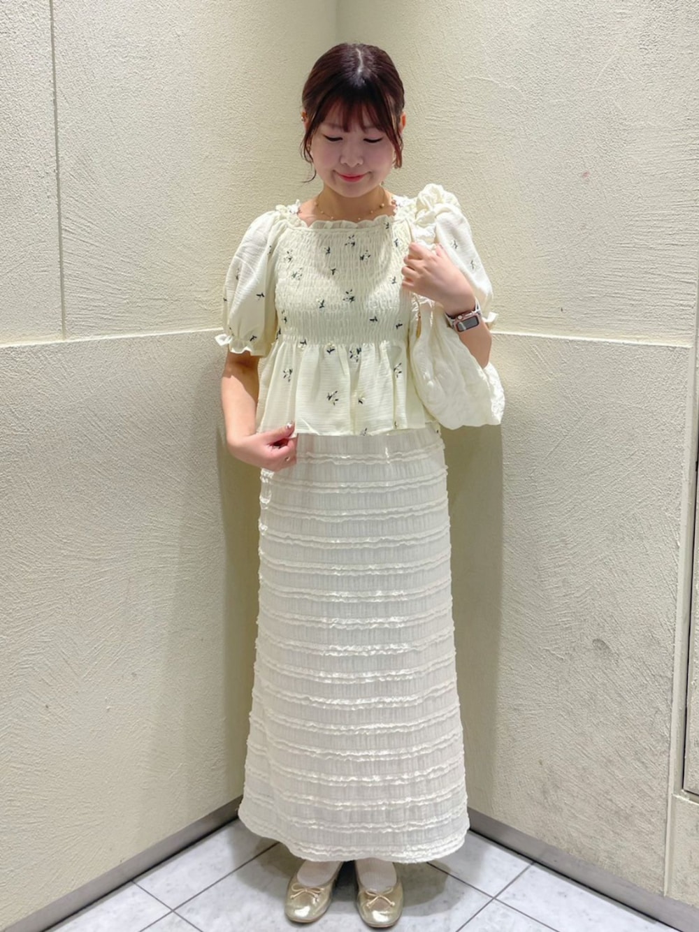 ホワイト系のショルダーバッグ、ホワイト系のスカート、イエロー系のシャツ/ブラウスを着用したレディースの夏コーディネートの1枚目の写真