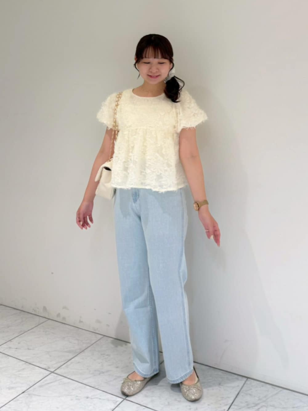 ブルー系のデニムパンツ、ホワイト系のシャツ/ブラウス、ホワイト系のショルダーバッグを着用したレディースの夏コーディネートの1枚目の写真