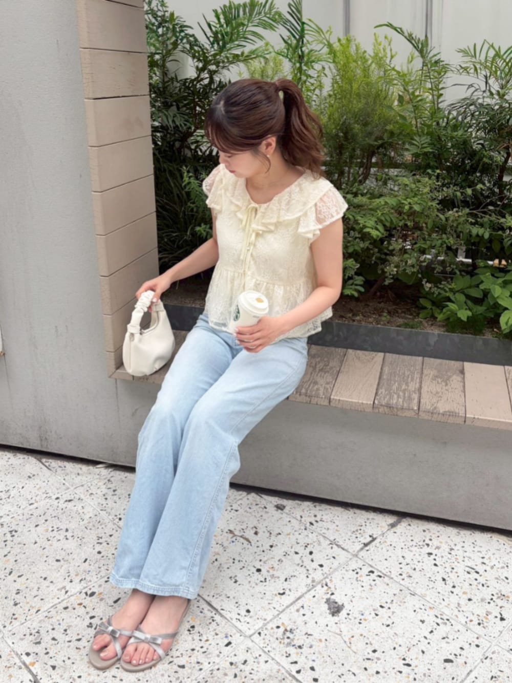 ブルー系のデニムパンツ、ホワイト系のショルダーバッグ、ホワイト系のシャツ/ブラウスを着用したレディースの春コーディネートの1枚目の写真