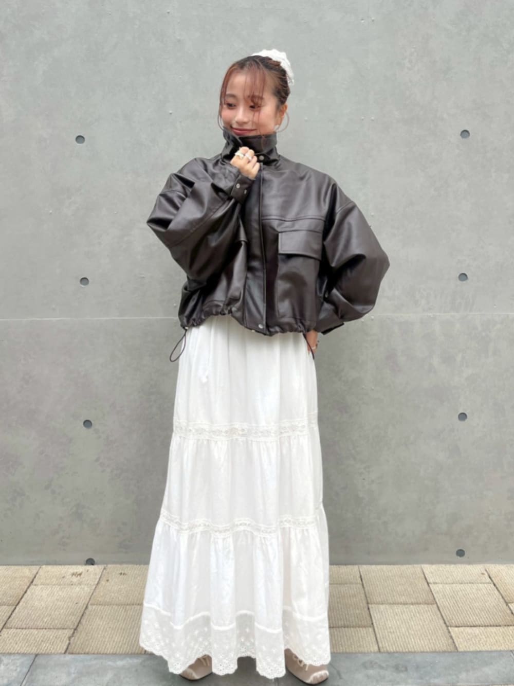 ホワイト系のスカート、ブラウン系のブルゾン、ブラウン系のシャツ/ブラウスを着用したレディースの秋コーディネートの1枚目の写真