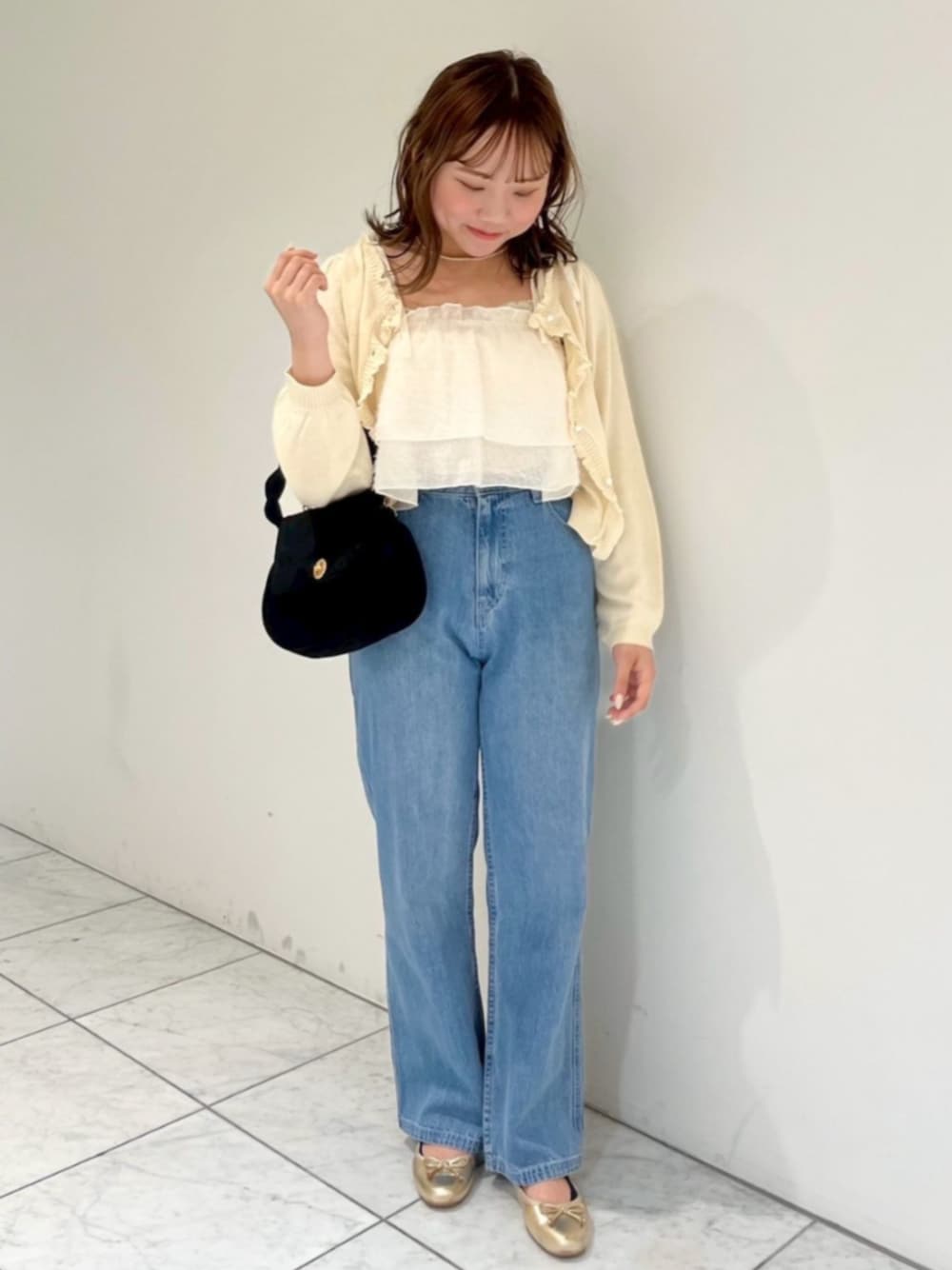 ブルー系のデニムパンツ、ブラック系のショルダーバッグ、ホワイト系のキャミソールを着用したレディースの秋コーディネートの1枚目の写真