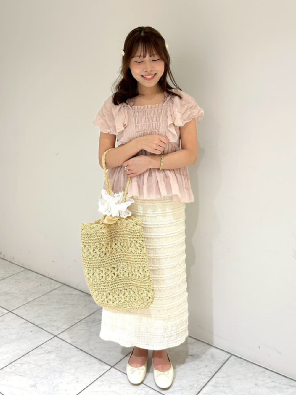 ホワイト系のスカート、ピンク系のシャツ/ブラウス、ベージュ系のトートバッグを着用したレディースの夏コーディネートの1枚目の写真