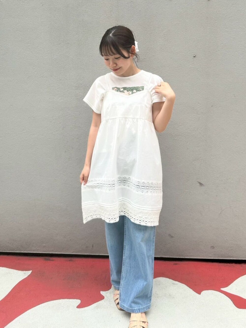 ブルー系のデニムパンツ、ホワイト系のワンピース、ピンク系のTシャツ/カットソーを着用したレディースの春コーディネートの1枚目の写真