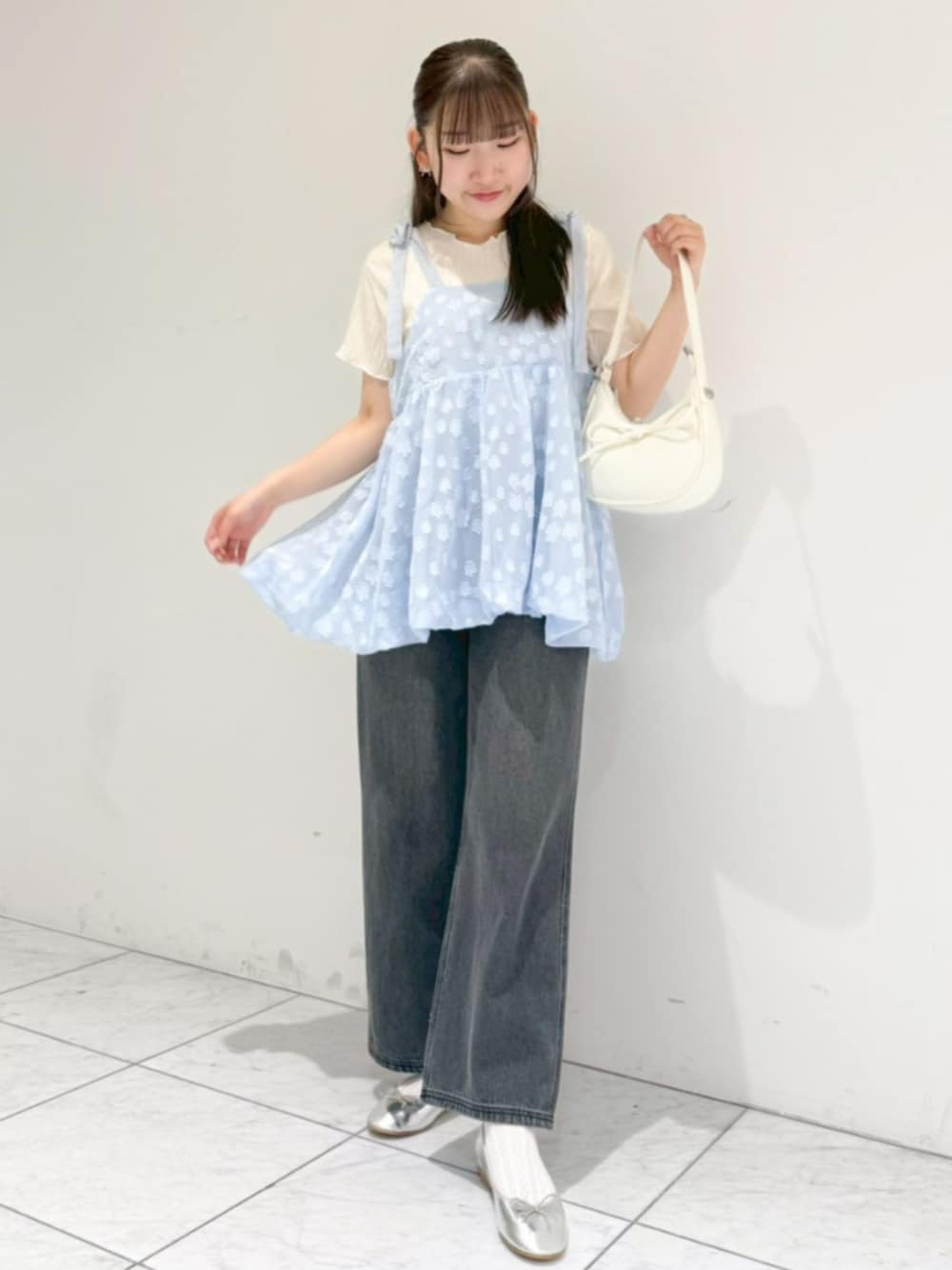 ホワイト系のTシャツ/カットソー、ブラック系のデニムパンツ、ホワイト系のショルダーバッグを着用したレディースの春コーディネートの1枚目の写真
