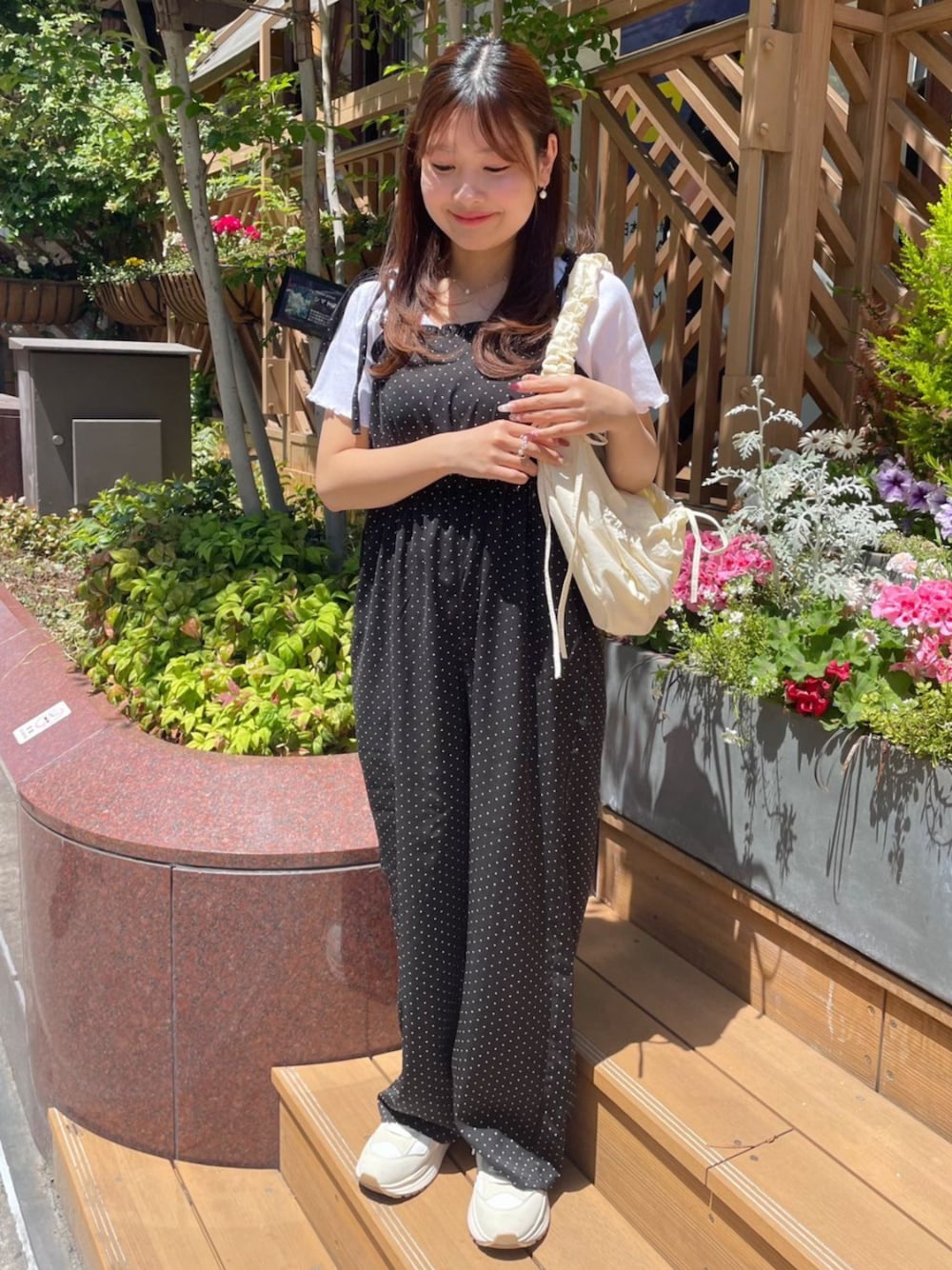 ホワイト系のショルダーバッグ、ブラック系のサロペット/オーバーオール、ホワイト系のTシャツ/カットソーを着用したレディースの春コーディネートの1枚目の写真