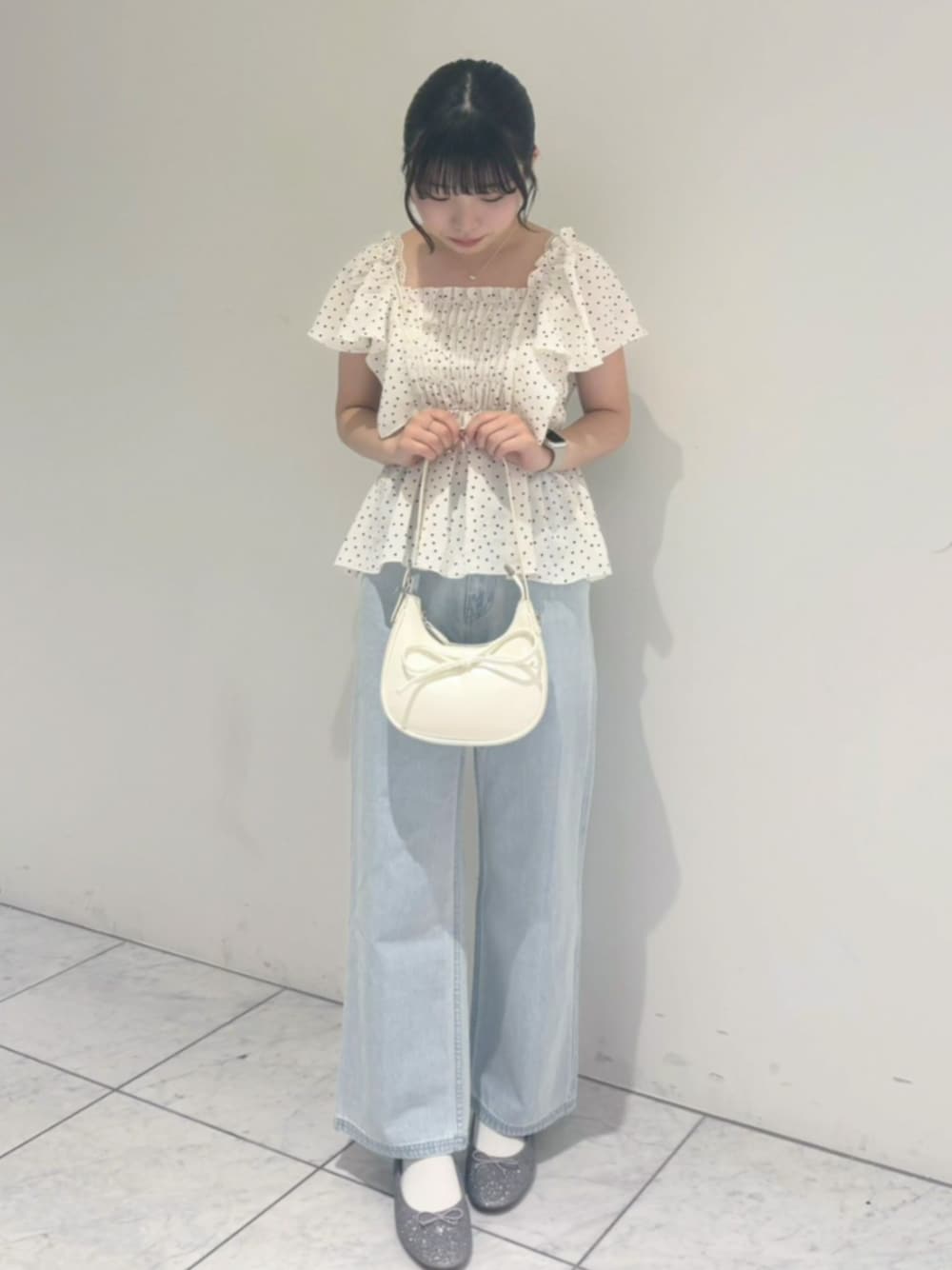 ブルー系のデニムパンツ、ホワイト系のショルダーバッグ、ホワイト系のシャツ/ブラウスを着用したレディースの春コーディネートの1枚目の写真